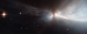 This striking new image, captured by the NASA/ESA Hubble Space Telescope, reveals a star in the process of forming within the Chamaeleon cloud. This young star is throwing off narrow streams of gas from its poles — creating this ethereal object known as HH 909A. These speedy outflows collide with the slower surrounding gas, lighting up the region. When new stars form, they gather material hungrily from the space around them. A young star will continue to feed its huge appetite until it becomes massive enough to trigger nuclear fusion reactions in its core, which light the star up brightly. Before this happens, new stars undergo a phase during which they violently throw bursts of material out into space. This material is ejected as narrow jets that streak away into space at breakneck speeds of hundreds of kilometres per second, colliding with nearby gas and dust and lighting up the region. The resulting narrow, patchy regions of faintly glowing nebulosity are known as Herbig-Haro objects. They are very short-lived structures, and can be seen to visibly change and evolve over a matter of years (heic1113) — just the blink of an eye on astronomical timescales. These structures are very common within star-forming regions like the Orion Nebula, or the Chameleon I molecular cloud — home to the subject of this image. The Chameleon cloud is located in the southern constellation of Chameleon, just over 500 light-years from Earth. Astronomers have found numerous Herbig-Haro objects embedded in this stellar nursery, most of them emanating from stars with masses similar to that of the Sun. A few are thought to be tied to less massive objects such as brown dwarfs, which are "failed" stars that did not hit the critical mass to spark reactions in their centres. A version of this image was entered into the Hubble's Hidden Treasures image processing competition by contestant Judy Schmidt.